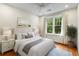 Calm bedroom featuring light-colored walls, hardwood floors, and view of lush greenery through the window at 273 12Th Ne St # 210, Atlanta, GA 30309