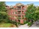 Multi-story brick condo building with balconies and mature trees, offering an urban living experience at 273 12Th Ne St # 210, Atlanta, GA 30309