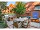 Outdoor kitchen and dining area with built-in grill, dining table, and manicured greenery at 273 12Th Ne St # 210, Atlanta, GA 30309