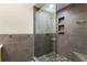 Modern shower featuring stylish tilework, sleek glass doors, and built-in shelving for storage and organization at 273 12Th Ne St # 210, Atlanta, GA 30309