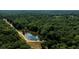 Aerial view of property highlighting a tranquil pond and surrounding forest at 4955 H D Atha Rd, Covington, GA 30014