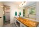 Updated bathroom with a butcher block countertop, white cabinets, and a large mirror at 4955 H D Atha Rd, Covington, GA 30014