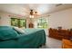 Comfortable bedroom with a green duvet, large windows, and a ceiling fan at 4955 H D Atha Rd, Covington, GA 30014