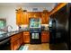 A fully-equipped kitchen features wooden cabinetry, black appliances, and granite countertops at 4955 H D Atha Rd, Covington, GA 30014