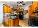 Spacious kitchen featuring wooden cabinetry, black appliances, and a decorative ceiling fan at 4955 H D Atha Rd, Covington, GA 30014