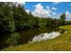 Serene pond view with lush green landscaping at 4955 H D Atha Rd, Covington, GA 30014