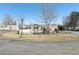 Tan mobile home with a fenced yard, shed, and landscaping at 127 Cambridge Ct, Hampton, GA 30228