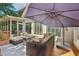 Back deck featuring wicker furniture with comfortable cushions and an umbrella for outdoor relaxation at 11050 Wilshire Chase Dr, Johns Creek, GA 30097