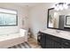 Bathroom with soaking tub, double vanity, and updated fixtures at 4222 Honey Creek Way, Powder Springs, GA 30127