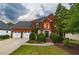 Charming two-story red brick home with a manicured front lawn and attached two car garage at 4222 Honey Creek Way, Powder Springs, GA 30127