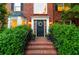 Elegant brick entrance with a black front door, decorative wreath, and lush greenery at 4222 Honey Creek Way, Powder Springs, GA 30127