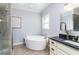 Bright bathroom features a soaking tub, black countertop vanity, and modern fixtures at 4801 Daniel Mill Rd, Winston, GA 30187