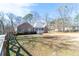 Brick home exterior with a long, fenced yard and mature trees, offering privacy and space at 4801 Daniel Mill Rd, Winston, GA 30187