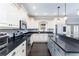 Kitchen boasts white cabinets, stainless appliances, black countertops, and island at 4801 Daniel Mill Rd, Winston, GA 30187