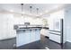 Bright, modern kitchen with white cabinets, an island, stainless steel appliances, and dark hardwood floors at 4801 Daniel Mill Rd, Winston, GA 30187