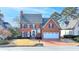 Brick two-story house with a large driveway and landscaping at 2389 Littlebrooke Dr, Dunwoody, GA 30338