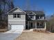 Two story home featuring gray siding, a two-car garage, covered porch, and professional landscaping at 250 Shawnee Trl, Dallas, GA 30157