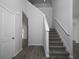 Hallway features wood-look flooring, neutral paint, and a staircase with carpeted steps at 250 Shawnee Trl, Dallas, GA 30157