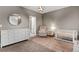 This Bedroom is styled with a white dresser, round mirror, rocking chair, and modern light fixture at 215 Arizona Ne Ave # 2, Atlanta, GA 30307