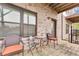 Covered brick patio features an outdoor dining set, privacy windows, and concrete flooring at 215 Arizona Ne Ave # 2, Atlanta, GA 30307