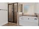 Bathroom showing glass enclosed shower and separate soaking tub with tile surround at 313 Pennant Ln, Fairburn, GA 30213