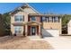 Two story house with brick and siding, two car garage, and landscaping at 313 Pennant Ln, Fairburn, GA 30213