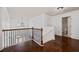 Bright hallway with wood floors, featuring an open railing and access to various rooms at 313 Pennant Ln, Fairburn, GA 30213