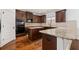 Modern kitchen features dark wood cabinets, granite countertops, and stainless steel appliances at 313 Pennant Ln, Fairburn, GA 30213