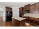 Stylish kitchen features dark wood cabinetry, granite countertops, and stainless appliances at 313 Pennant Ln, Fairburn, GA 30213
