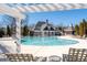 Community swimming pool with lounge chairs, tables, and clubhouse in the background on a sunny day at 313 Pennant Ln, Fairburn, GA 30213