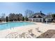 Community swimming pool with lounge chairs, tables, and clubhouse in the background at 313 Pennant Ln, Fairburn, GA 30213