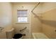 This functional bathroom includes a toilet, window, grab bar, and tub with neutral walls at 4453 White Oak Dr, Sugar Hill, GA 30518
