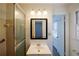 The neutral bathroom is lit by a three-light vanity and includes a shower at 4453 White Oak Dr, Sugar Hill, GA 30518