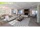 Bright, staged living room features a fireplace, white sofa, area rug and dining area at 4453 White Oak Dr, Sugar Hill, GA 30518
