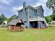 Expansive backyard featuring a wooden playhouse and large deck, perfect for outdoor entertainment and Gathering fun at 305 Rampart St, Mcdonough, GA 30253