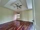 Spacious bedroom featuring dark wood floors, tray ceiling with fan, and natural light at 305 Rampart St, Mcdonough, GA 30253