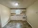 Compact kitchen offers white cabinets, modern appliances, and sleek gray wood grain flooring at 305 Rampart St, Mcdonough, GA 30253