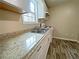 Close up of kitchen features granite countertops, stainless steel sink and modern appliances for meal prep at 305 Rampart St, Mcdonough, GA 30253