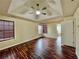Spacious main bedroom featuring tray ceilings, a ceiling fan, and gleaming hardwood floors at 305 Rampart St, Mcdonough, GA 30253
