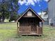 Wooden playhouse in backyard with a small porch and picket fence at 305 Rampart St, Mcdonough, GA 30253