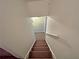 A carpeted staircase featuring neutral walls and minimal design, leading to upper level at 305 Rampart St, Mcdonough, GA 30253