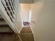 Carpeted staircase with white railing leads upstairs, bright with natural light from above at 305 Rampart St, Mcdonough, GA 30253