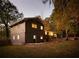 Rear view of a ranch house with gray siding and a large backyard at 3512 Casa Woods Ln, Clarkston, GA 30021