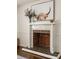 White fireplace mantel with brick hearth and a stylish artwork at 3512 Casa Woods Ln, Clarkston, GA 30021