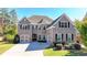 Brick two-story house with a three-car garage and manicured lawn at 1190 Smithwell Pt, Kennesaw, GA 30152