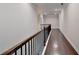 Upstairs hallway with hardwood floors and dark wood railing at 1190 Smithwell Pt, Kennesaw, GA 30152
