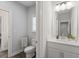 Well-lit bathroom featuring a white vanity, toilet, and view into a secondary room at 6320 Halcyon Garden Dr, Alpharetta, GA 30005