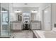 Bright bathroom with dual vanities, granite counters, large mirrors and glass shower with decorative tile and white cabinets at 6320 Halcyon Garden Dr, Alpharetta, GA 30005