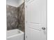 Bright bathroom features a tub, shower, tiled wall, and crisp white door at 6320 Halcyon Garden Dr, Alpharetta, GA 30005