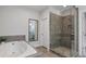 Elegant bathroom featuring a soaking tub, walk-in shower, and stylish tile work at 6320 Halcyon Garden Dr, Alpharetta, GA 30005